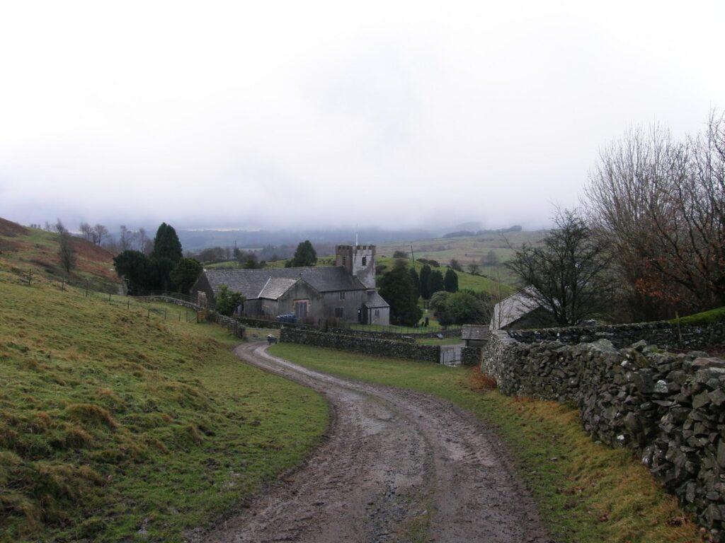 a dirt path leading to a countryside house